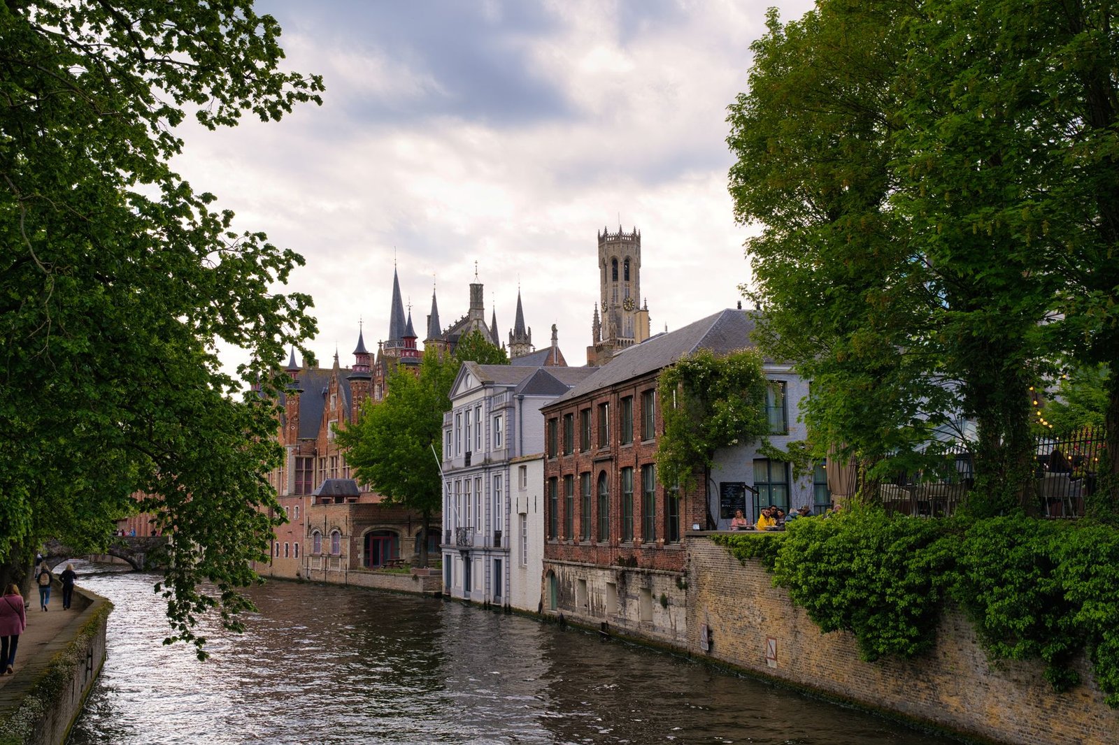 Rustige wandelweg langs het water in een Vlaamse stad bij zonsondergang