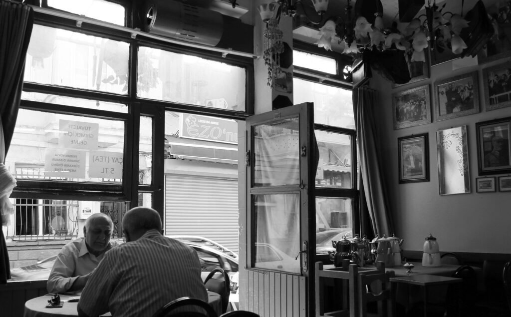 Twee volwassenen in een rustig gesprek aan een tafel in een koffiehuis