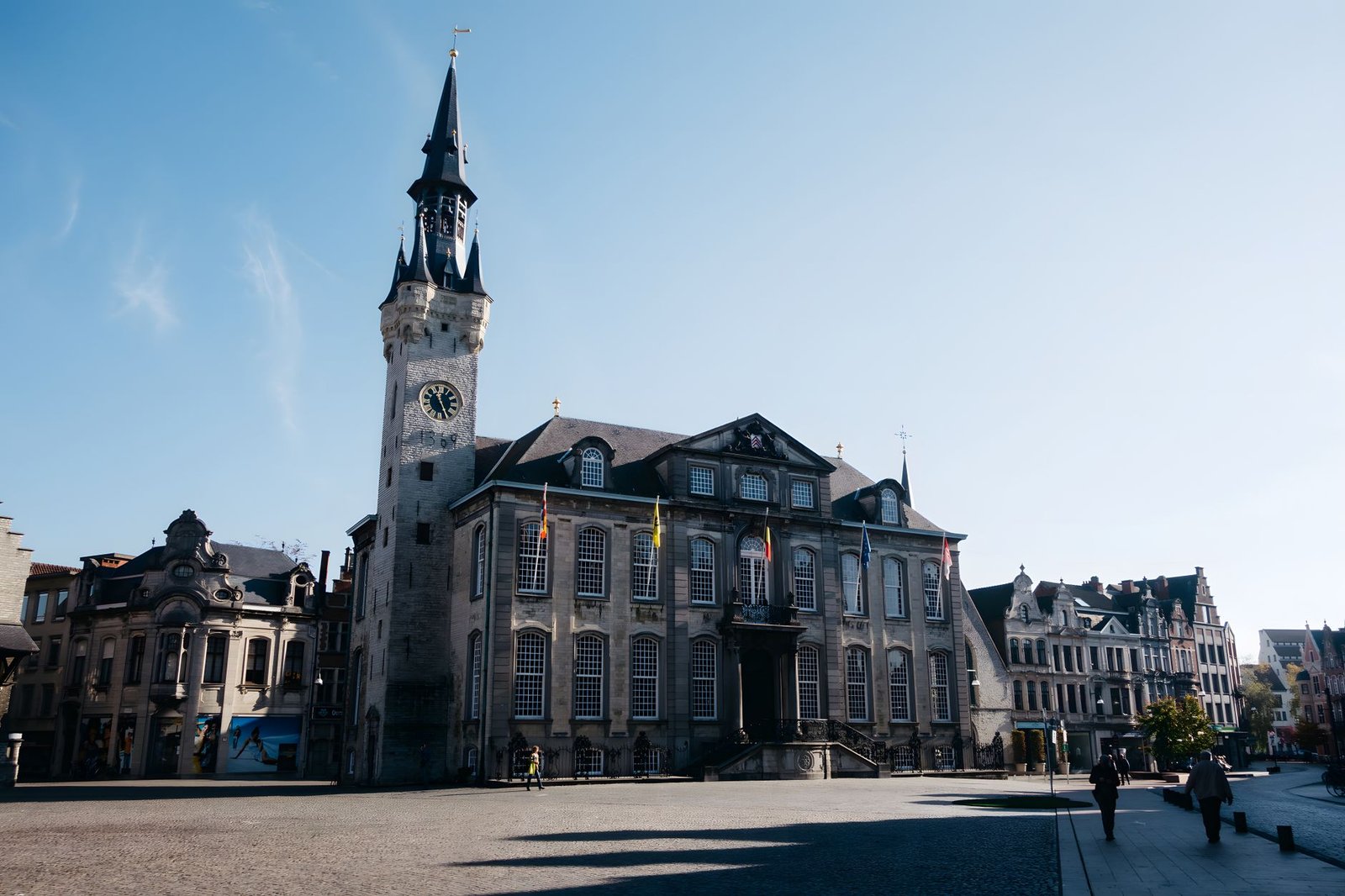 Historisch stadsplein in Lier bij zonsondergang met kasseien en een rustig terras