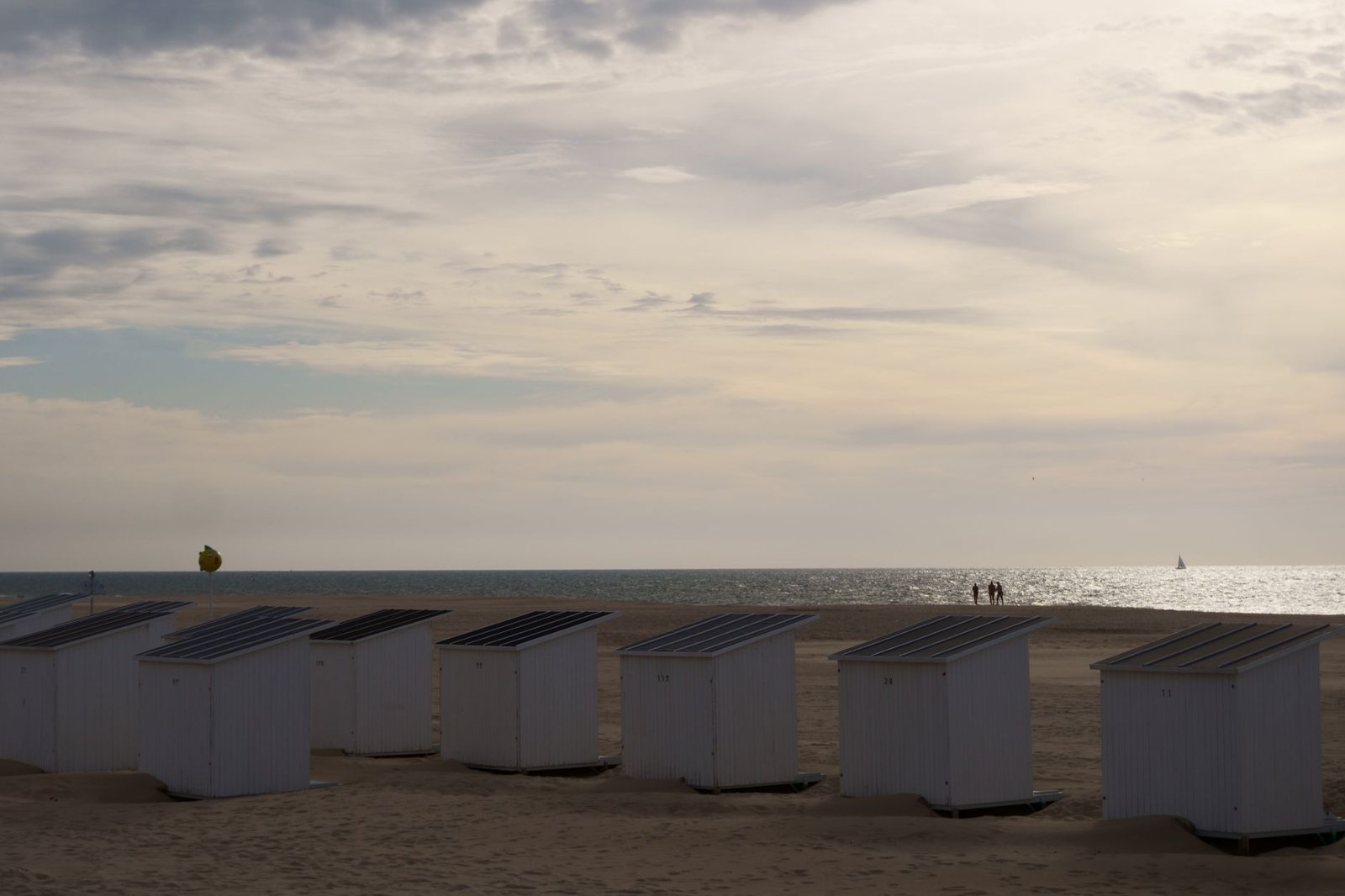 Wandelaar op de zeedijk van Oostende in zacht avondlicht, rustige kustsfeer