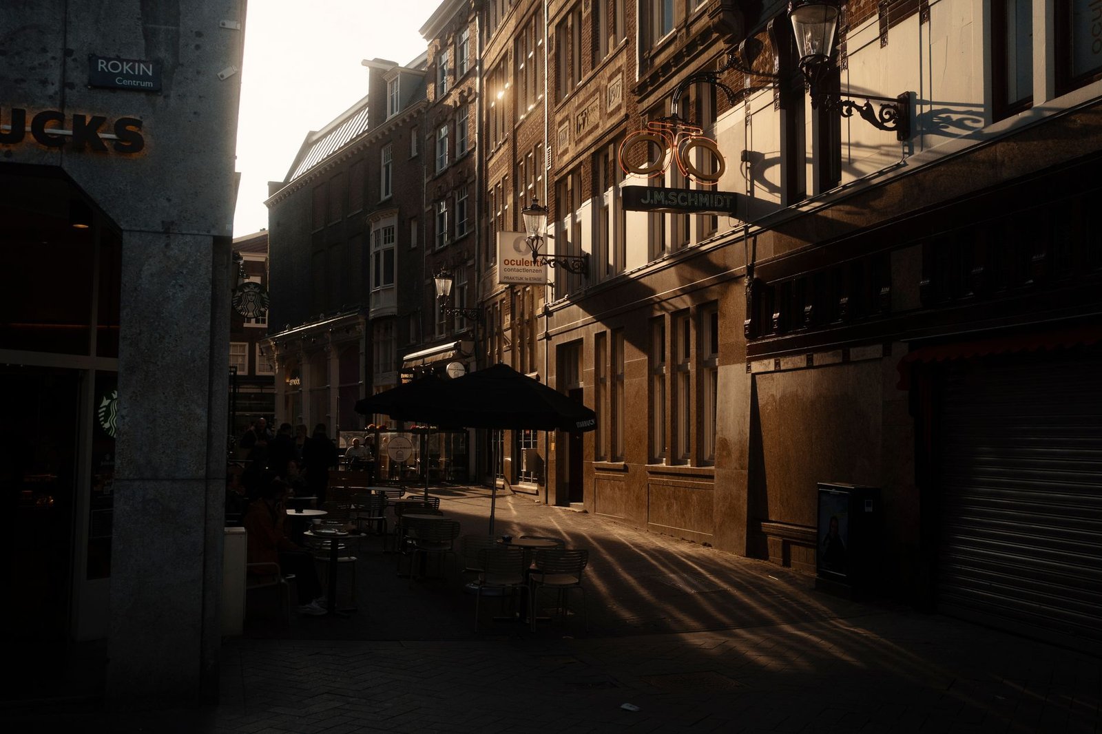 Rustige straat in Roeselare met historische gebouwen en een caféterras in het avondlicht