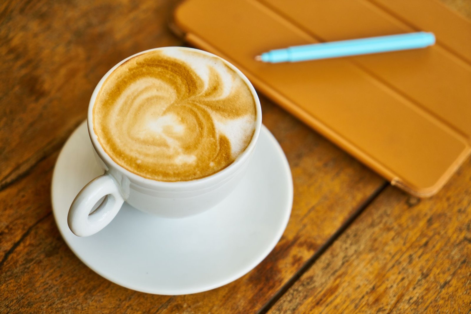 Rustige tafel met notitieboek en koffie, symbool voor discreet plannen van een ontmoeting in Zaventem