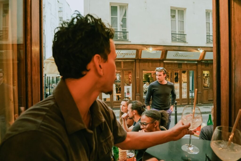 Twee volwassenen in gesprek aan een tafel in een rustige brasserie