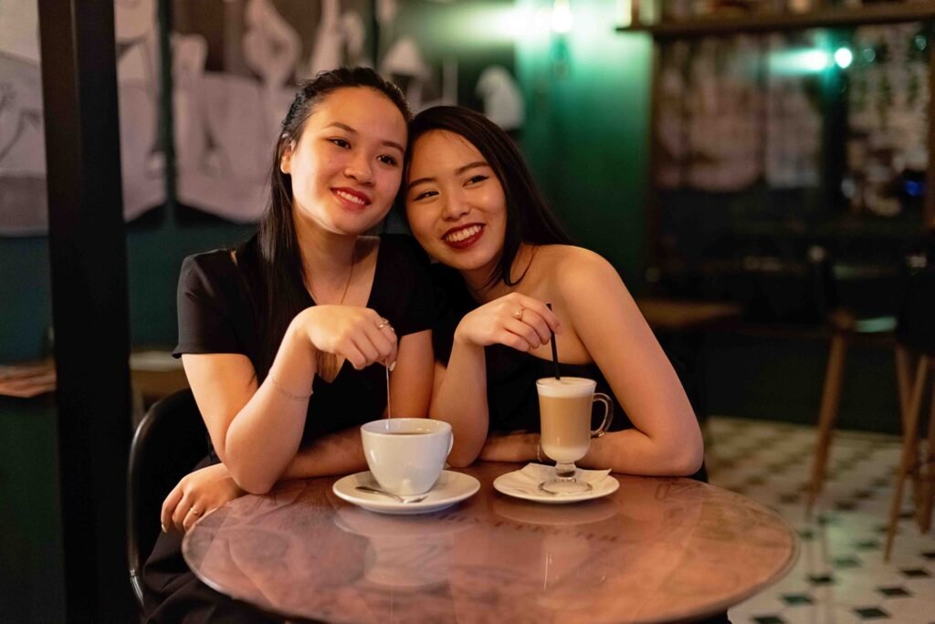 Twee mensen in een discreet gesprek aan een tafeltje in een café bij warm licht