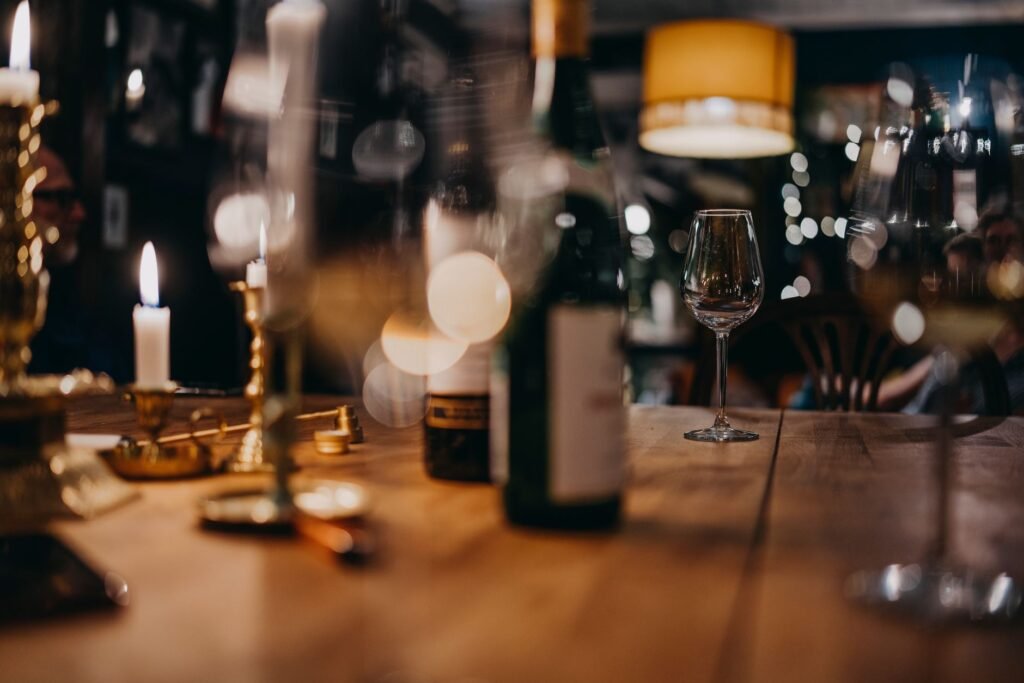 Gedekte tafel met kaars en wijnglazen in een avondlijke brasserie in BelgiΓ«