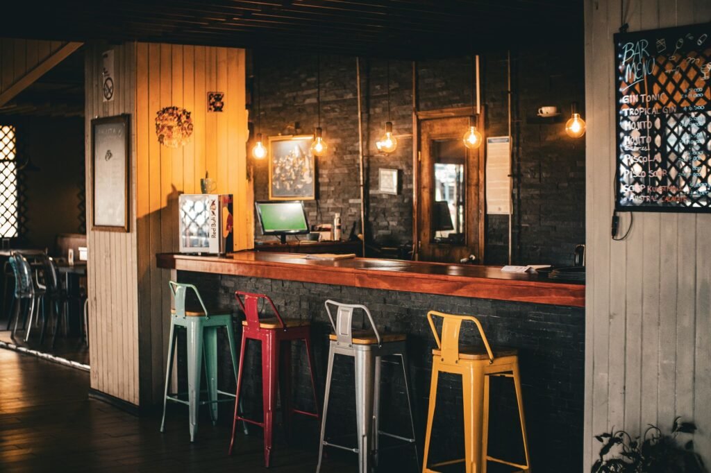 Knusse bar bij avond met warm licht en houten toog in Mons