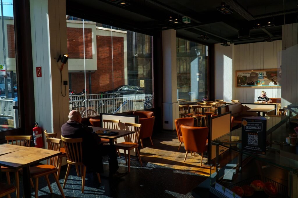 Intérieur d'un café calme à Bruxelles avec une table près de la fenêtre, lumière douce de l'après-midi