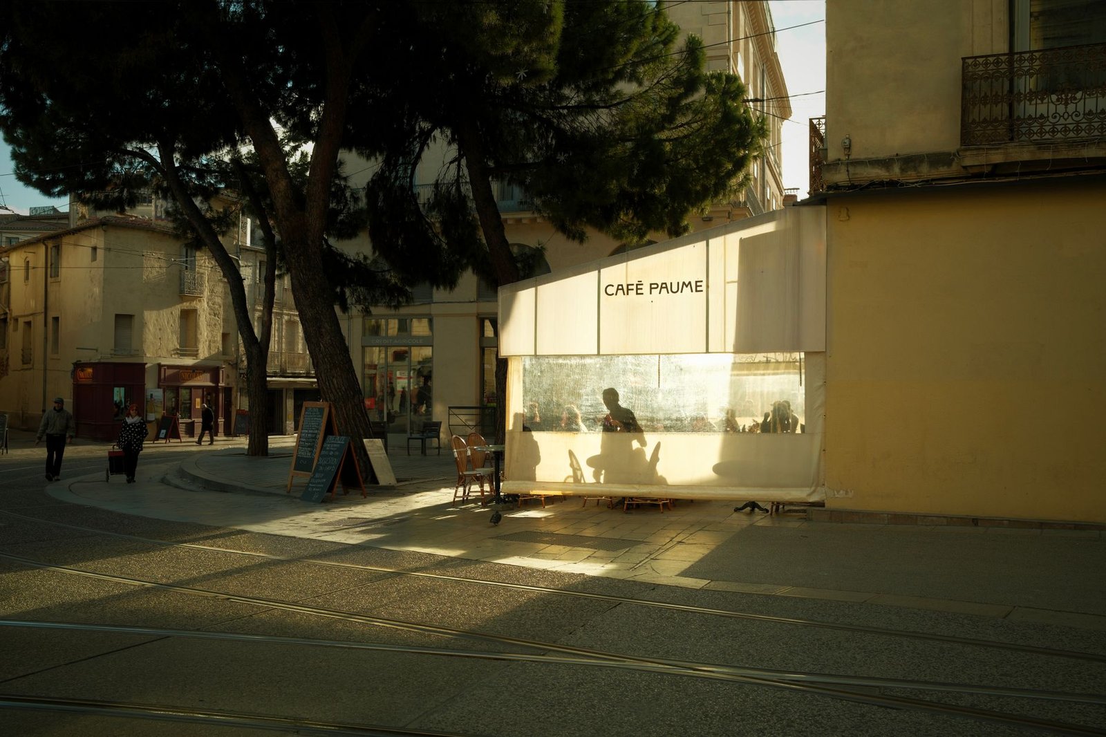 Table de café discrète en terrasse au crépuscule, cadre neutre pour une rencontre adulte