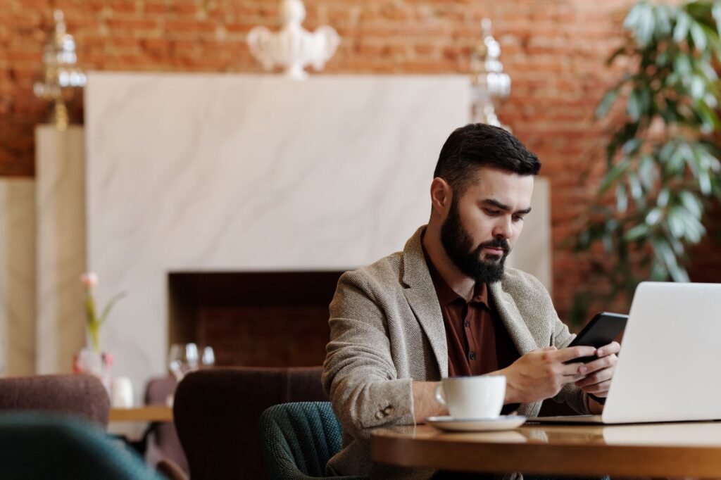 Handen typen een beleefd bericht op een smartphone in een rustig café