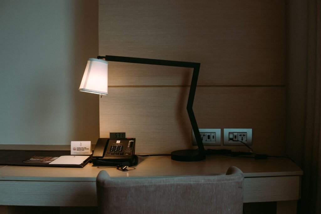 Hotelkamer met bureau, notitieboek en telefoon, symbool voor voorbereiding en discretie