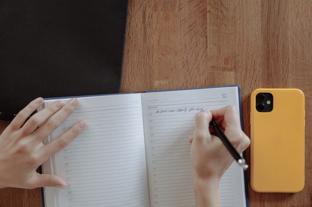 Smartphone en notitieboek op een houten tafel bij daglicht