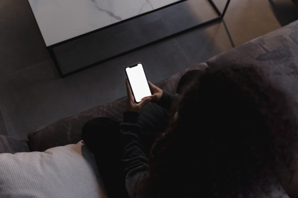 Personne consultant discrètement son téléphone pour préparer un premier contact respectueux.