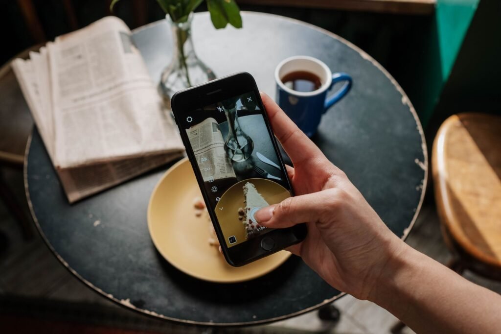 Smartphone met het scherm naar beneden op een tafel naast een kop koffie