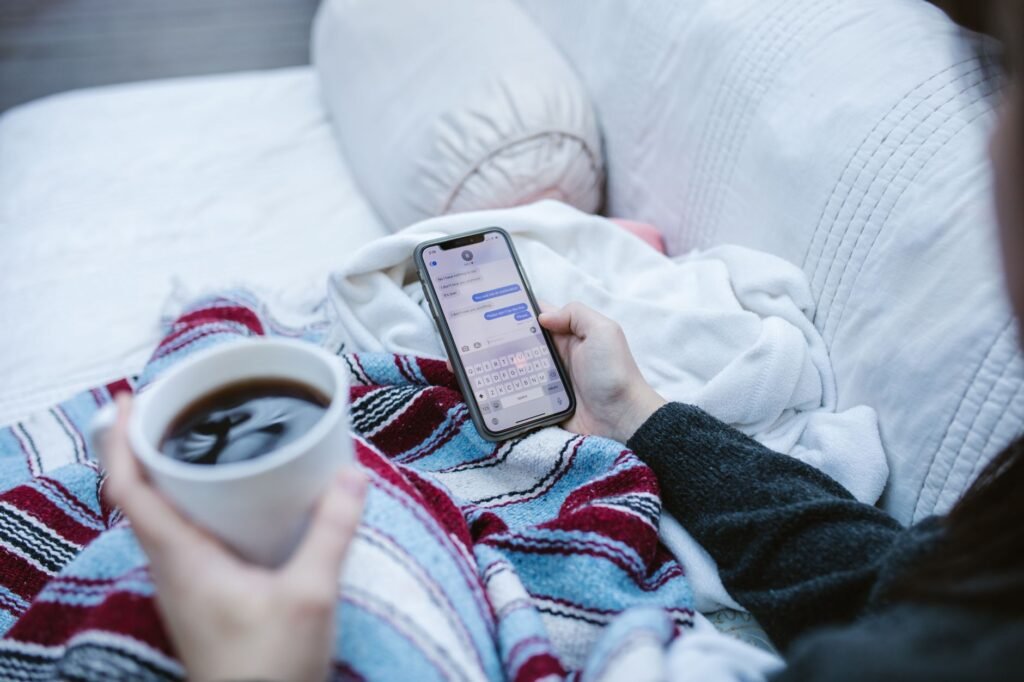 Personne rédigeant un message courtois sur smartphone dans un appartement bruxellois lumineux