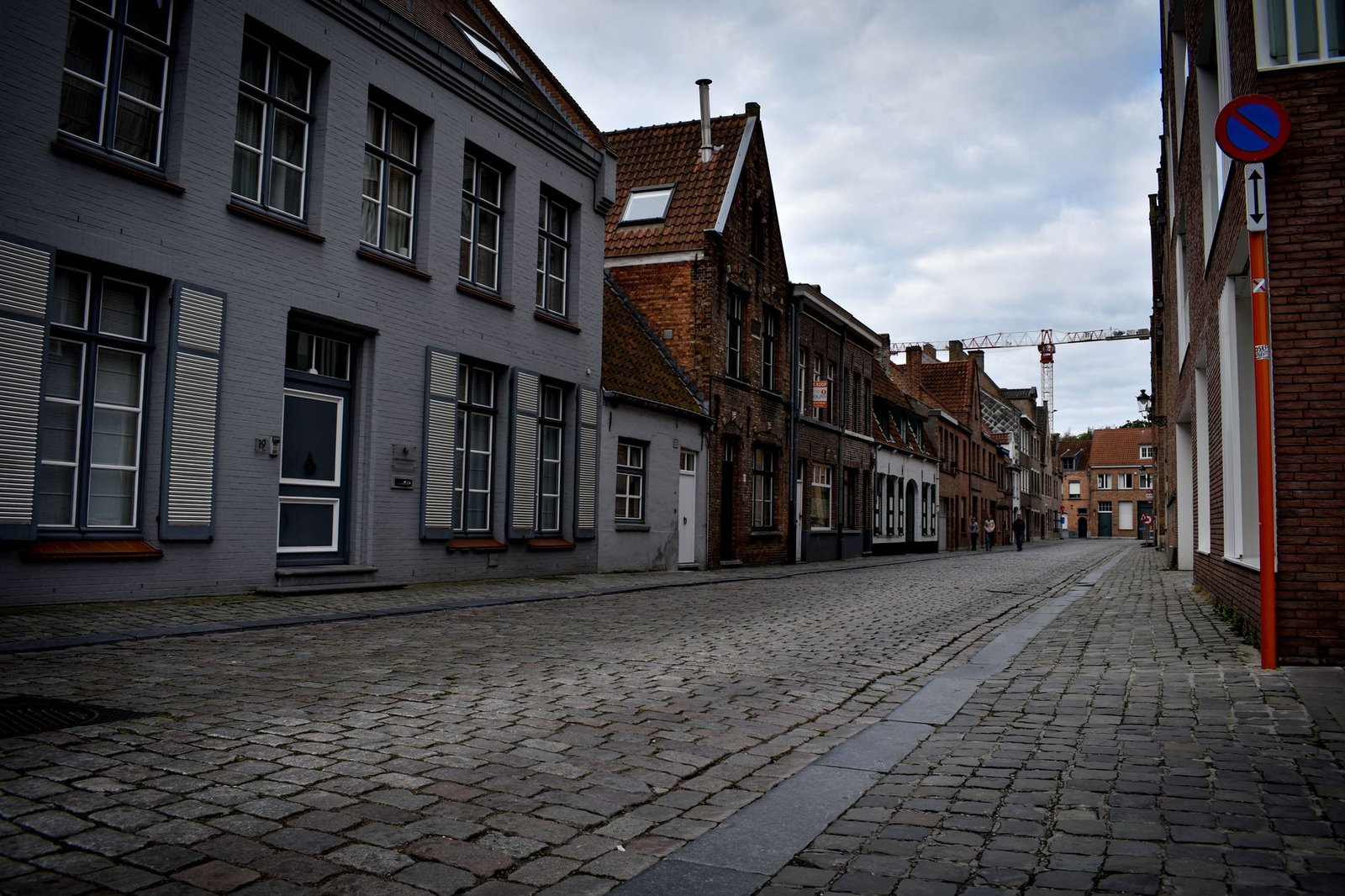 Rue calme d'une petite ville historique belge au crépuscule, ambiance discrète
