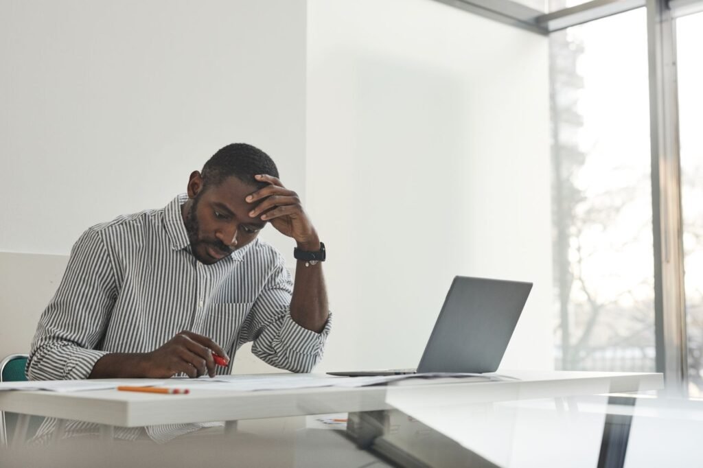 Iemand leest aandachtig een profiel op een laptop aan een bureau bij daglicht