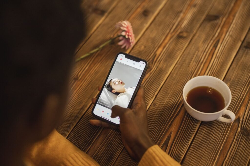 Smartphone op een cafetafel naast een kop koffie, symbool voor het rustig verkennen van een escortprofiel