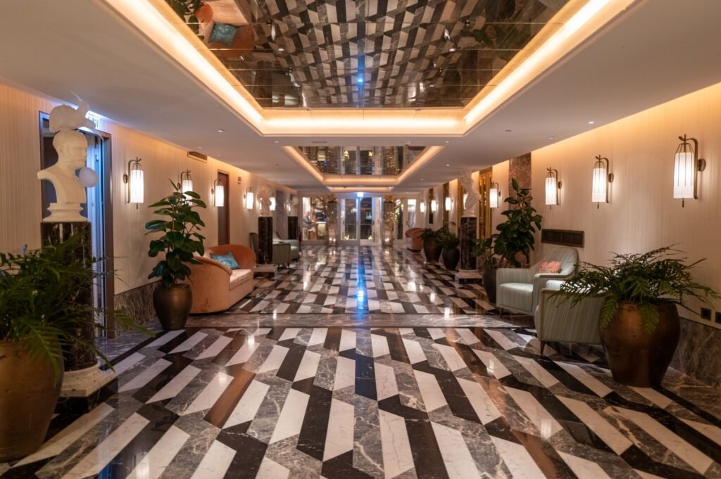 Persoon zit rustig aan een tafeltje in een discrete hotellobby in België