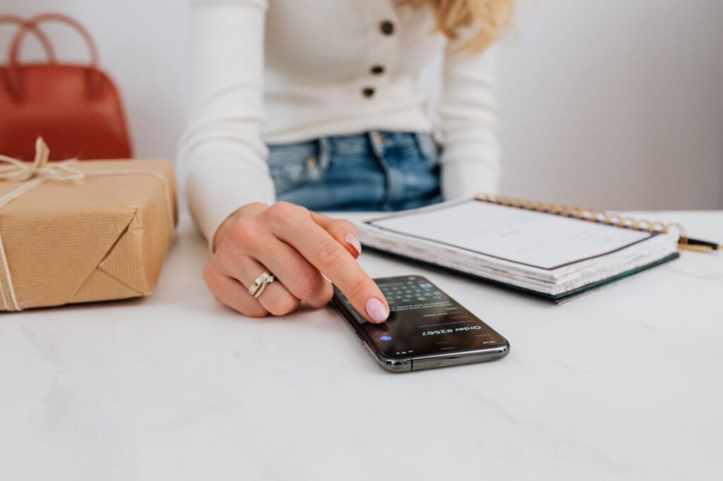 Smartphone en notitieboek op een houten tafel bij een eerste contact voor een escortafspraak