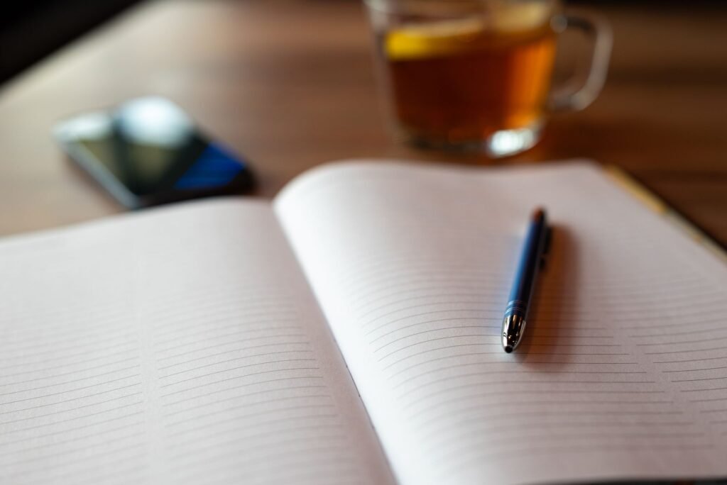 Telefoon, notitieboek en koffiekopje op een tafel tijdens het plannen van een afspraak