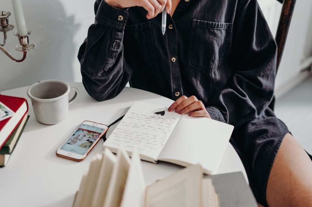 Smartphone en notitieboekje op een houten tafel bij een kop koffie, voorbereiding van een eerste afspraak