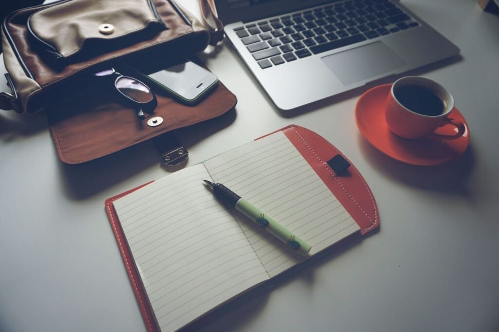 Telefoon, notitieboek en koffie op een tafel als beeld van voorbereiding en planning voor een eerste escortafspraak
