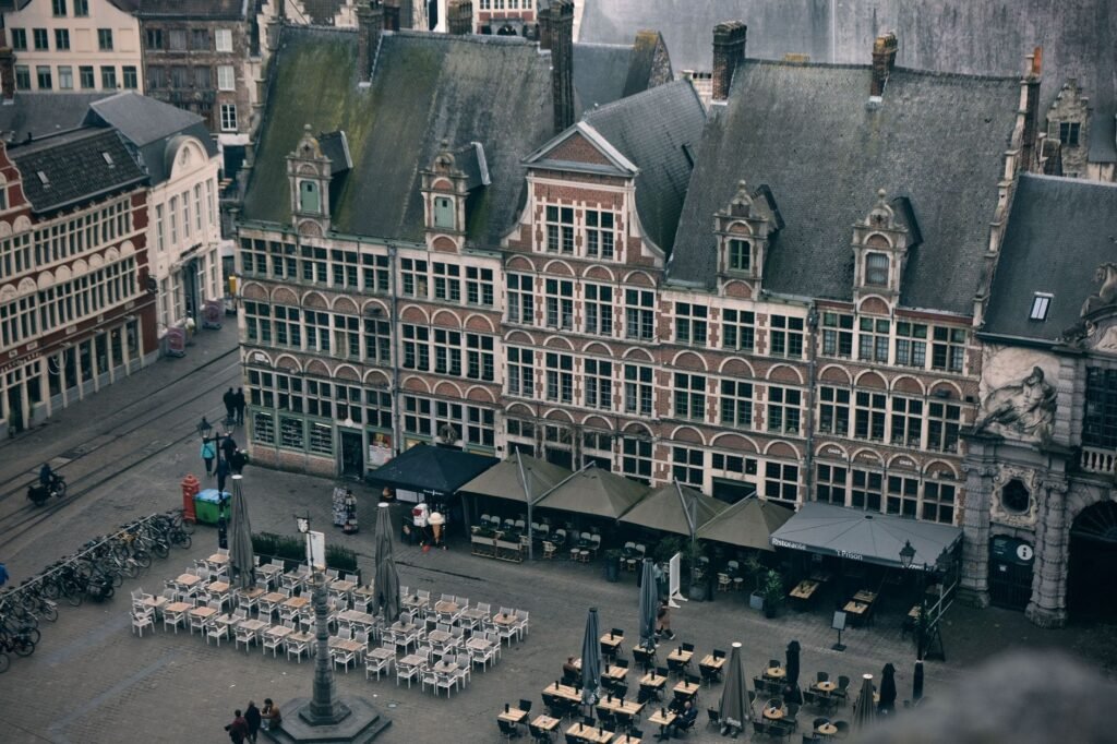 Rustig dorpsplein in Vlaams-Brabant met terras en bakstenen gebouwen in de namiddag