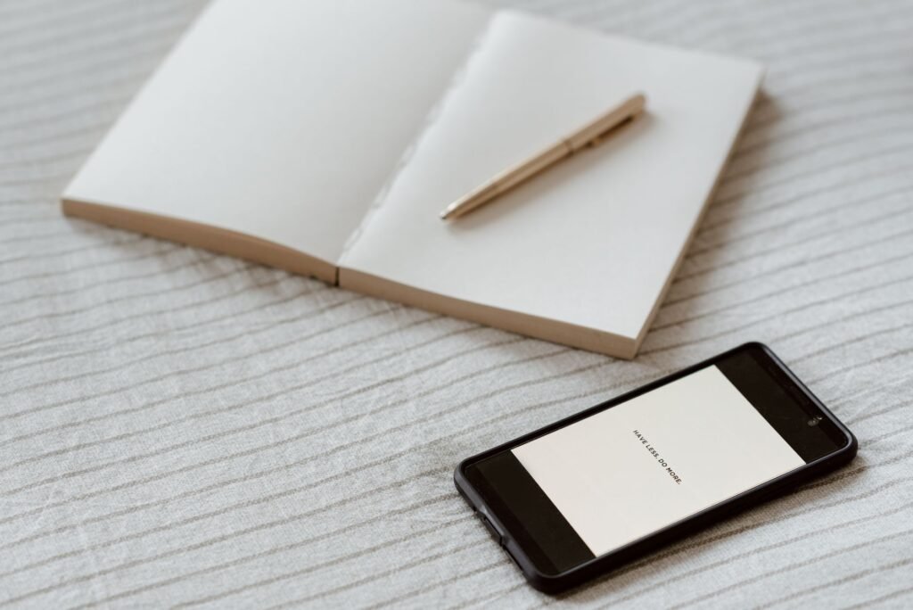 Téléphone et carnet sur une table pour préparer un message discret et respectueux