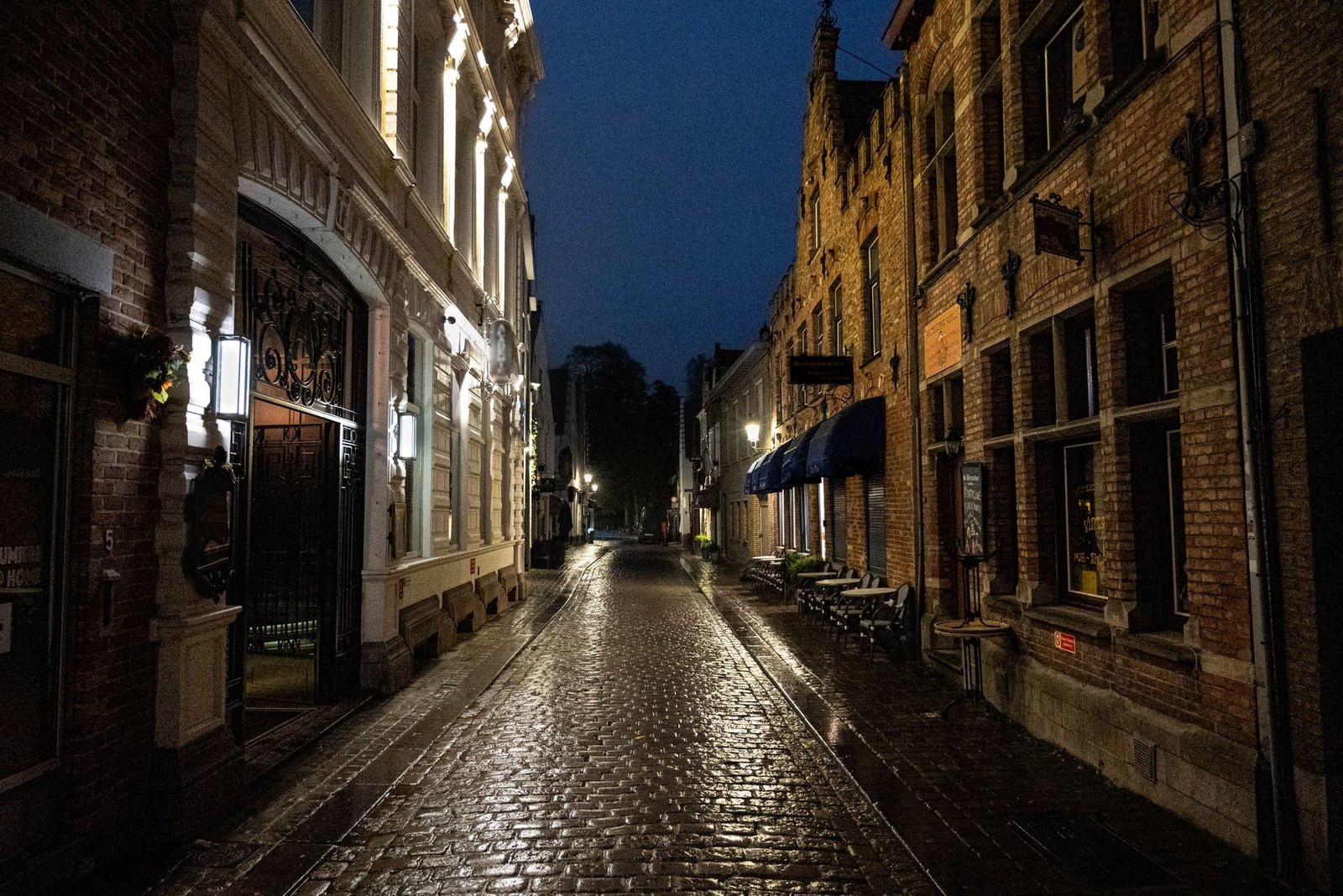 Rustige straat in een West-Vlaamse stad bij valavond met warme straatverlichting