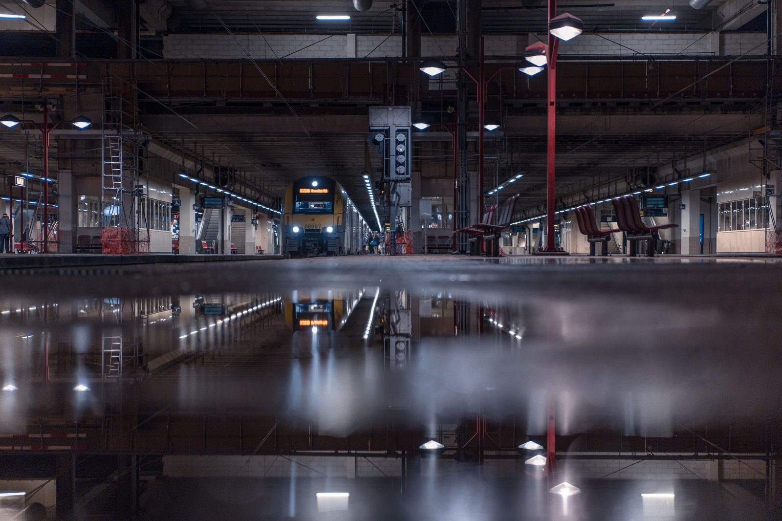 Quai de gare paisible au crépuscule dans une ville belge, illustrant la discrétion des déplacements