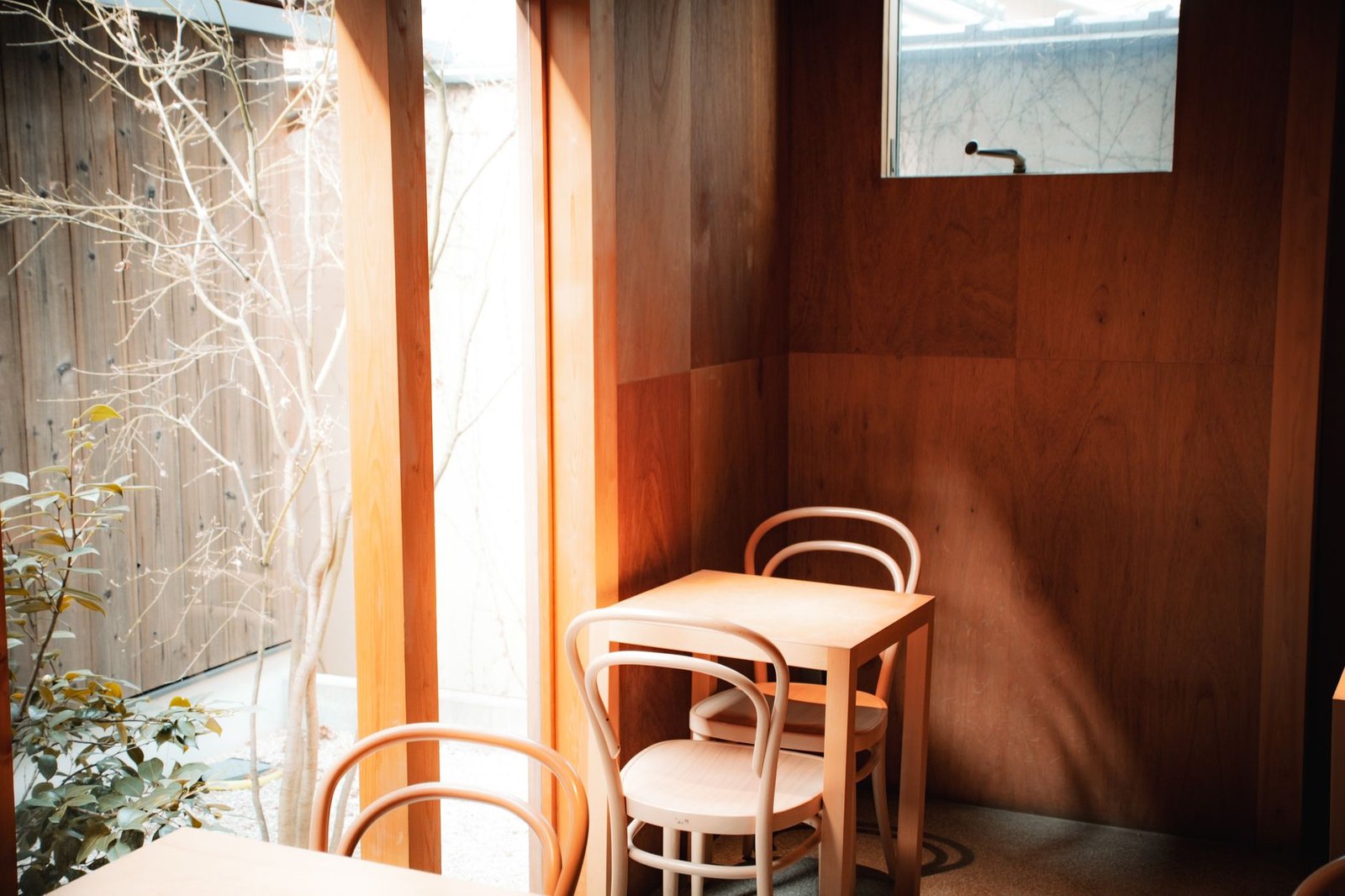 Table de café près d'une fenêtre avec deux tasses et un carnet, ambiance discrète à Rochefort