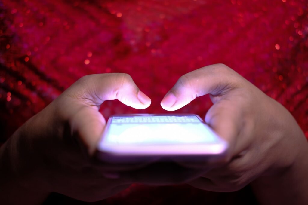 Mains rédigeant un premier message respectueux sur un smartphone dans un café lumineux avant une rencontre à Arlon
