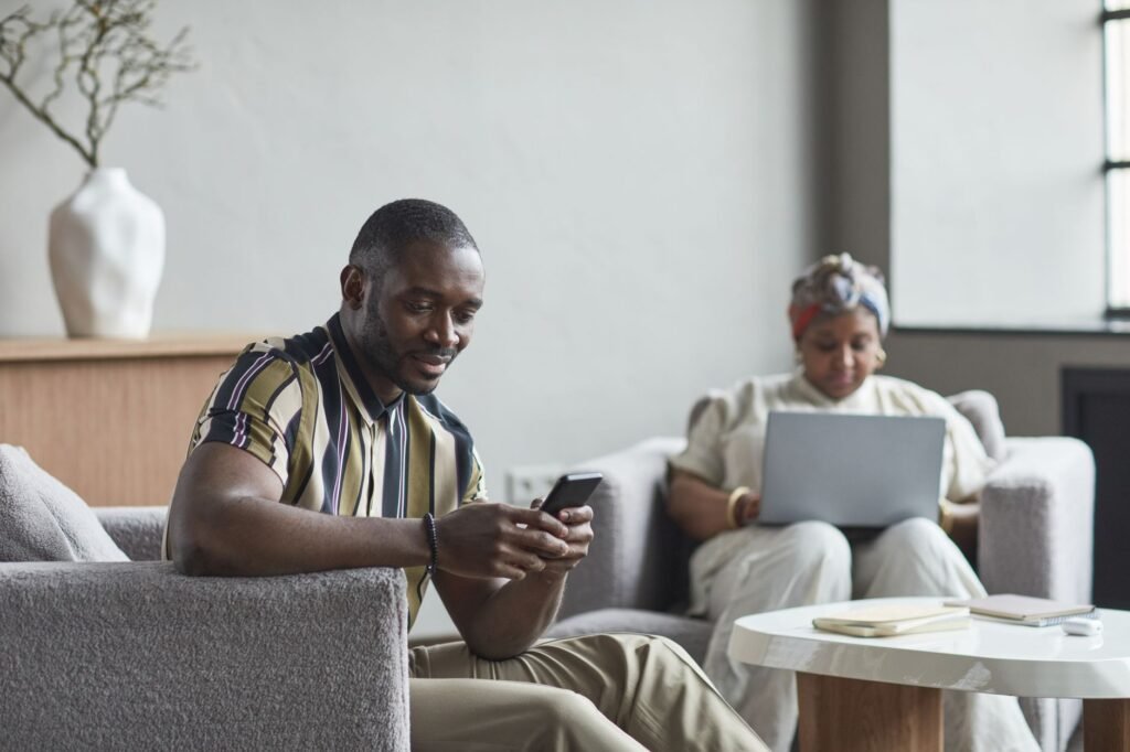 Persoon checkt telefoon in een rustige hotellobby, discreet en respectvol