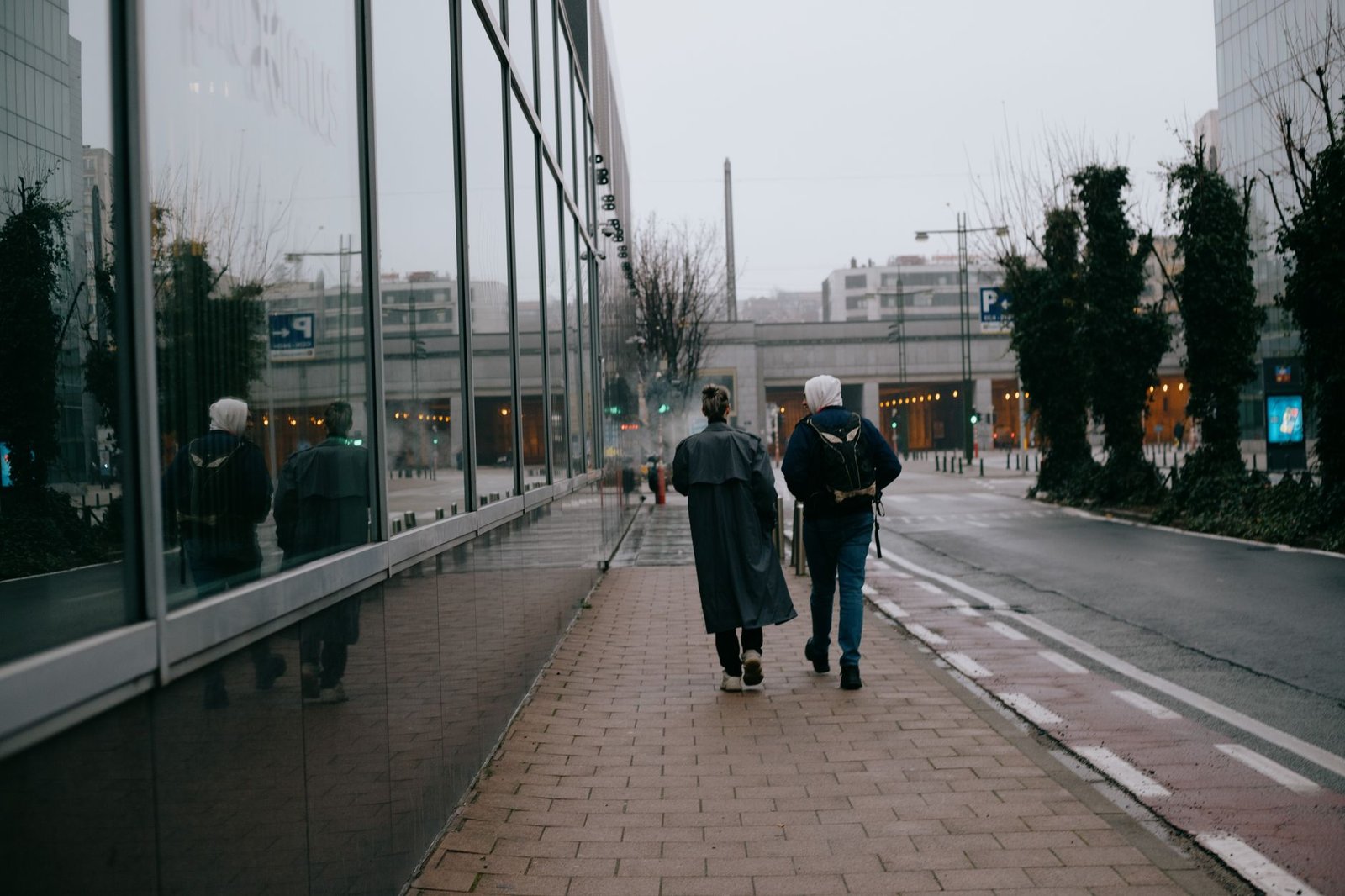 Volwassenen wandelen op een rustige kade langs de Maas in Andenne tijdens goudkleurig licht