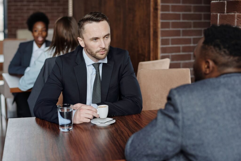 Twee volwassenen in gesprek aan een cafetafel