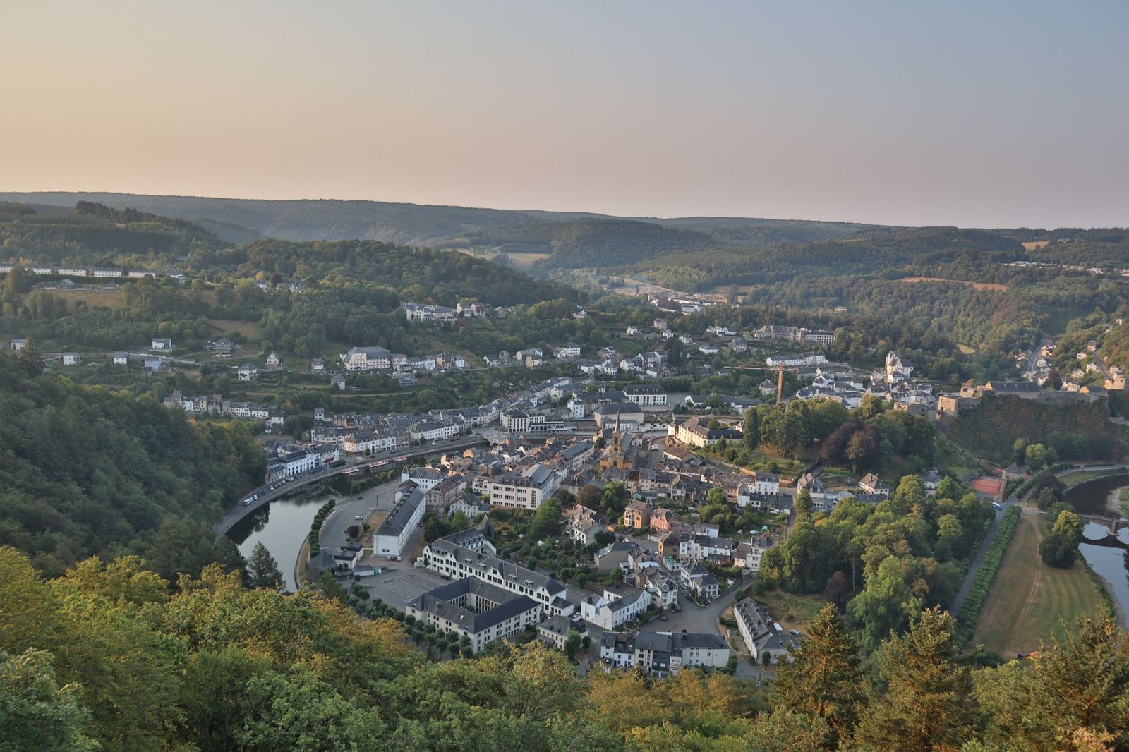 Uitzicht op de middeleeuwse vesting van Bouillon in de avond boven de rustige Semois