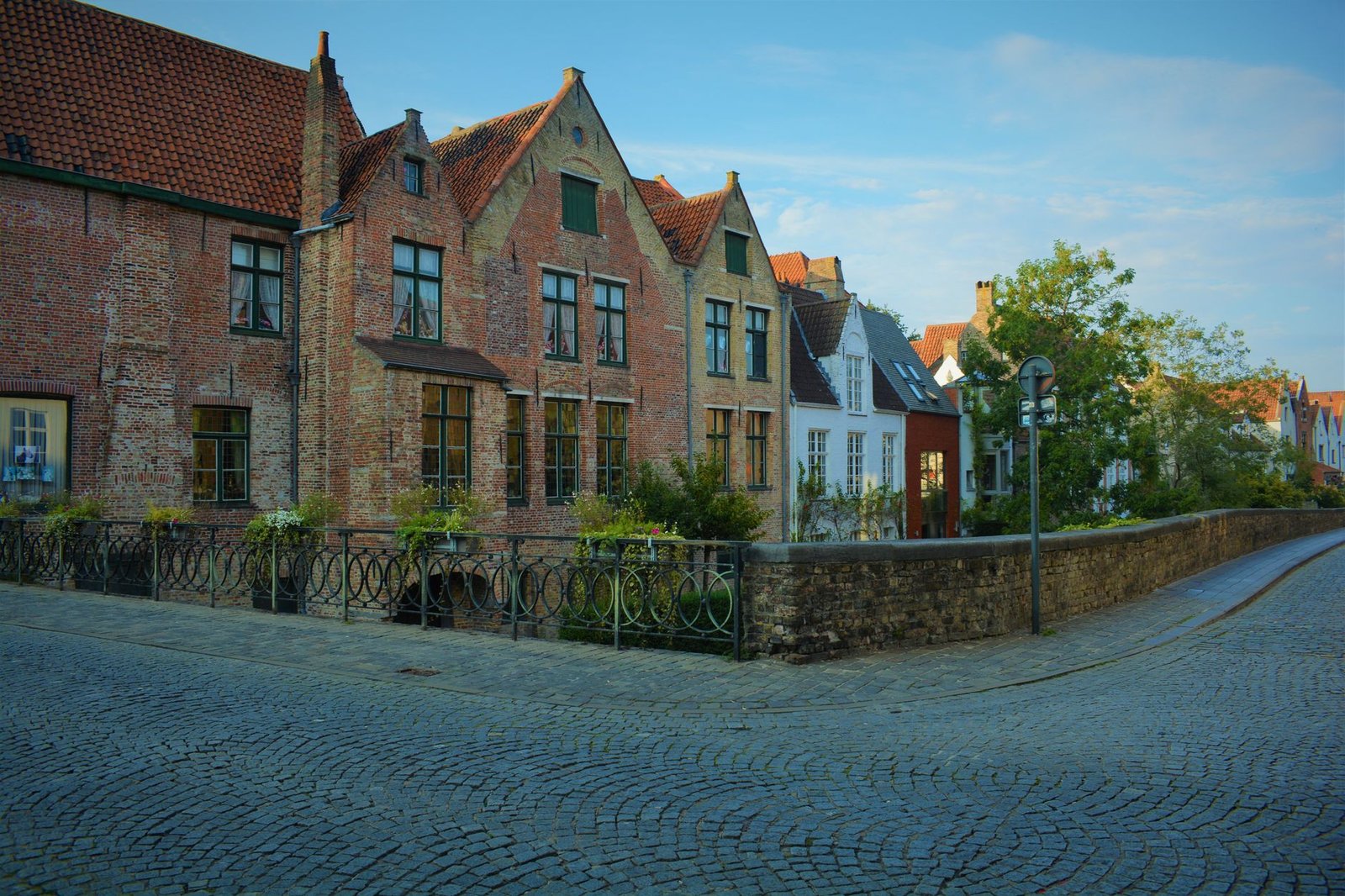 Stille avond aan een gracht in Brugge met warme verlichting en kasseien